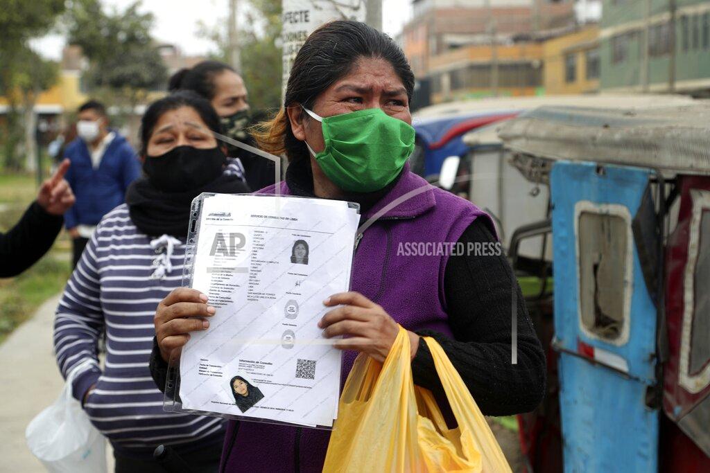 Martin Mejia A woman cries as she holds a photo of her daughter who died during a stampede at a disco, outside of a police station in Lima, Peru, Sunday, Aug. 23, 2020. Officials said over a dozen people died in a stampede at a disco in Peru after a police raid to enforce the country's lockdown during the coronavirus pandemic. (AP Photo/Martin Mejia)