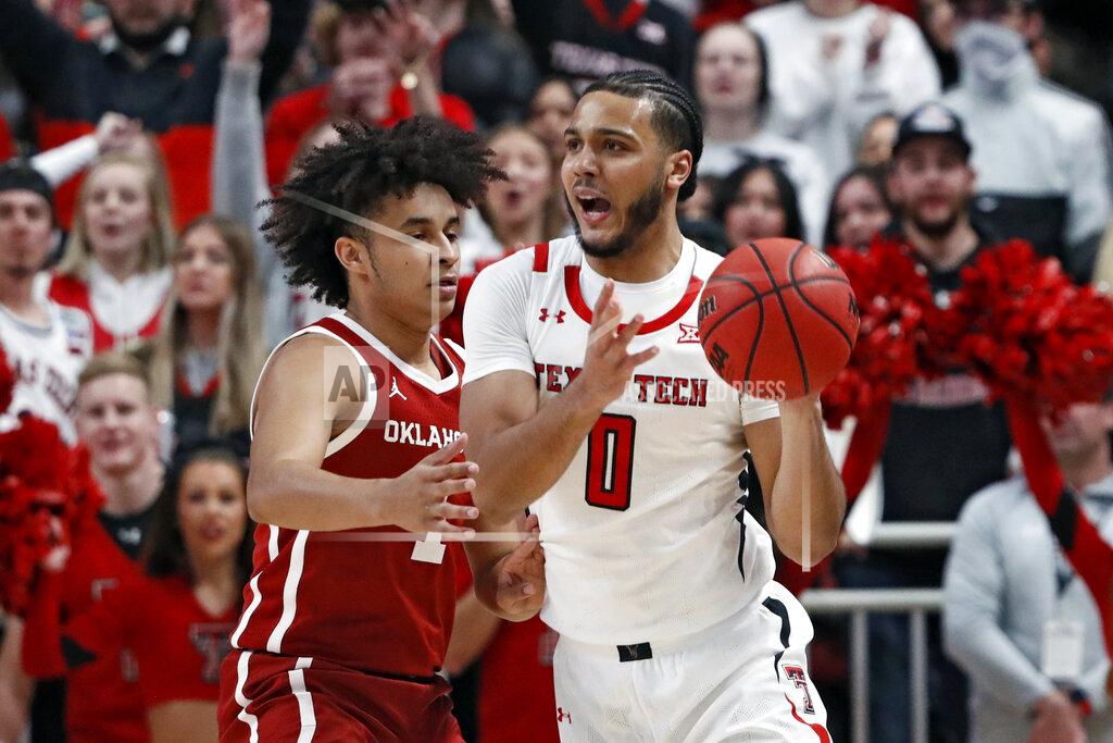 Brad Tollefson Texas Tech's Kevin Obanor (0) passes the ball around Oklahoma's Jalen Hill (1) during the first half of an NCAA college basketball game Tuesday, Feb. 22, 2022, in Lubbock, Texas. (AP Photo/Brad Tollefson)