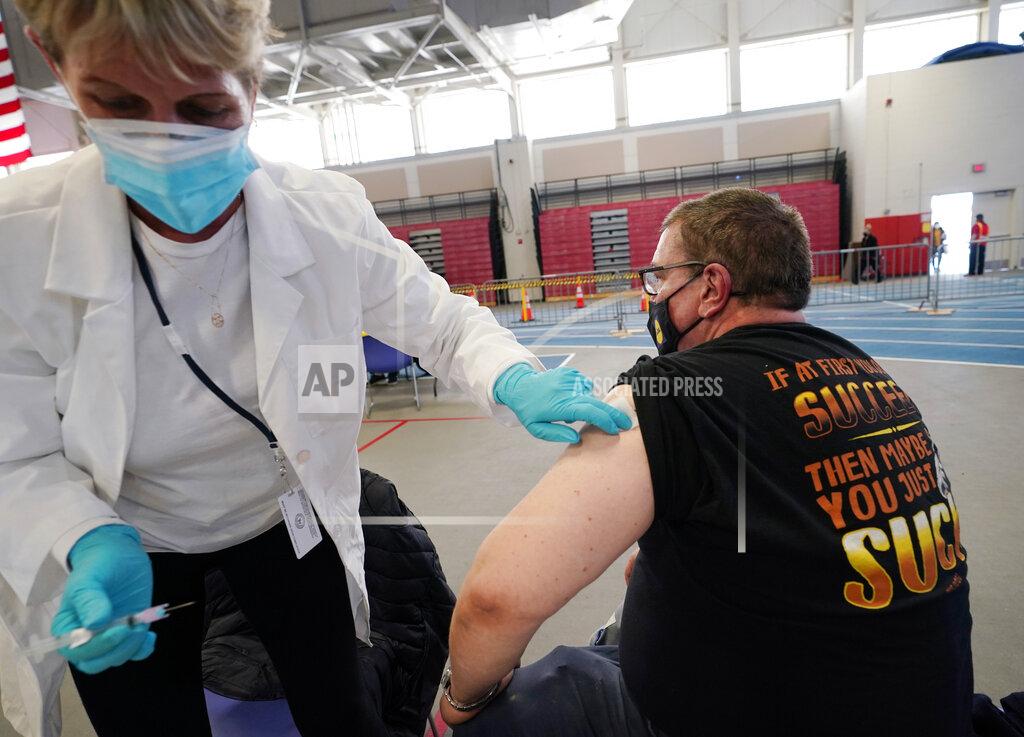 Kathy Willens In this Thursday, Feb. 4, 2021 photo, licensed practical nurse Sandra Reeve, left, holds an alcohol swab on the arm of grocery worker Joseph Lupo after administering the first dose of a COVID-19 vaccination to Lupo at an arena on the campus of Suffolk County Community College, Thursday, Feb. 4, 2021, in Brentwood, N.Y. Lupo, a Lidl supervisor who fell ill with the virus in March, was elated to get his first vaccine dose. "I never ever want to get COVID again, or see anybody else get it," said Lupo, 59. (AP Photo/Kathy Willens)