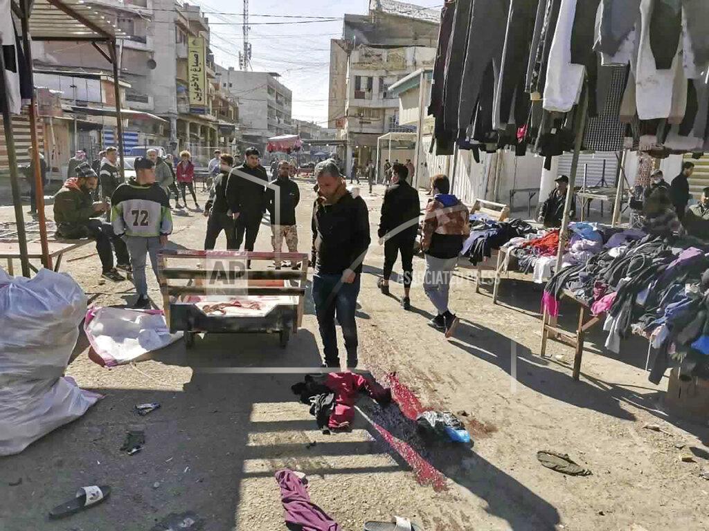 Hadi Mizban People and security forces gather at the site of a deadly bomb attack in Baghdad's bustling commercial area, Iraq, Thursday, Jan. 21, 2021. Twin suicide bombings hit Iraq's capital Thursday killing and wounding civilians, police and state TV said. (AP Photo/Hadi Mizban)