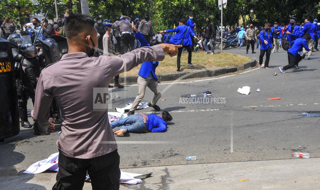 Police officers disperse student protesters during a protest against a controversial omnibus bill on job creation in Cikarang, West Java, Indonesia, Wednesday, Oct. 7, 2020. Thousands of Indonesian students and laborers protested on Wednesday against the new law they say cripples labor rights and harms the environment. (AP Photo/Septian)