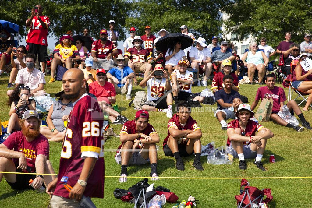 FILE - Washington Football Team fans watch drills during NFL football practice in Richmond, Va., in this Wednesday, July 28, 2021, file photo. It's not exactly everyone into the pool, or gathering around the bonfire. The NFL's “Back Together Saturday” at training camps is all about football. Well, also about having fans return to watch, with all 32 teams conducting open practices on Saturday as part of a unified effort by the league. (AP Photo/Ryan M. Kelly, File)