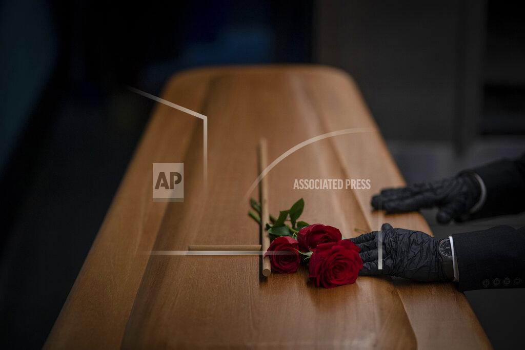 Emilio Morenatti A mortuary worker prepares the coffin carrying the body of a person who died of COVID-19 before being cremated during a funeral at Mémora mortuary in Girona, Spain, Thursday, Nov. 19, 2020. (AP Photo/Emilio Morenatti)
