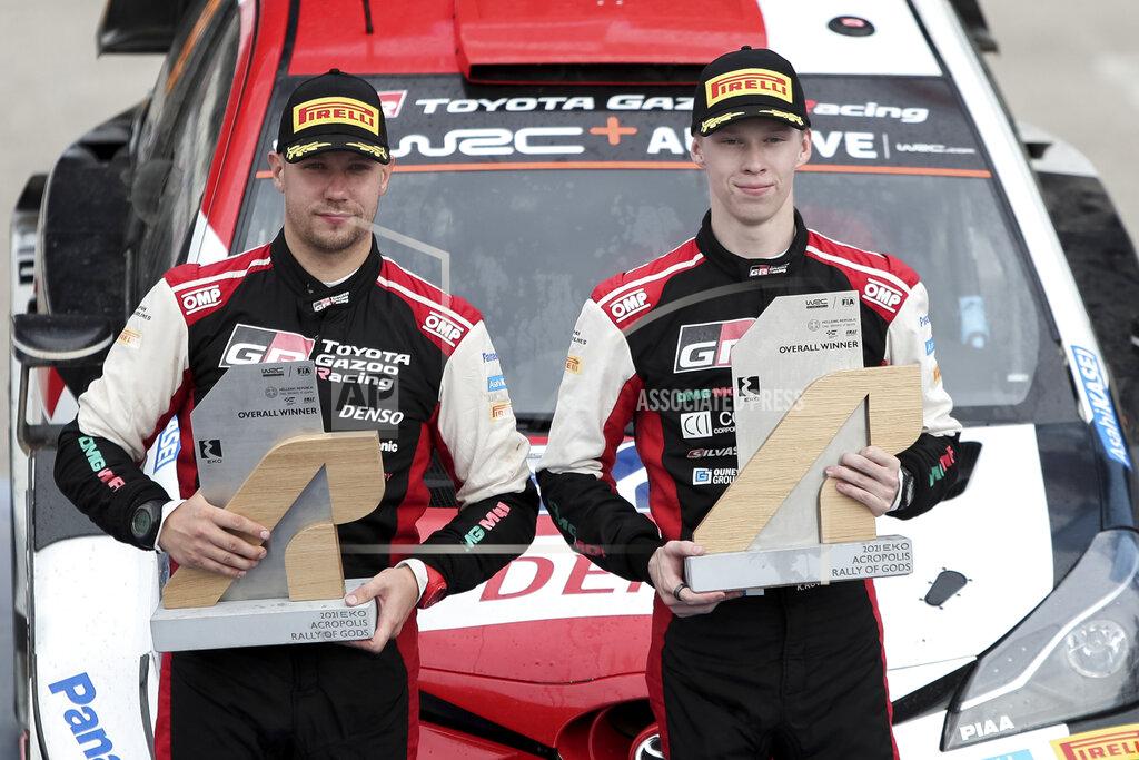 Klodian Lato Kalle Rovanpera, right, and his co-driver Jonne Halttunen of Finland hold their trophies after winning the WRC Acropolis Rally, near Lamia, northwest of Athens, Greece, Sunday, Sept. 12, 2021. The Finnish crew of Kalle Rovanpera and Jonne Halttunen has won the Acropolis Rally, after leading through most of the four-day World Rally Championship race. (Klodian Lato/Eurokinissi via AP)