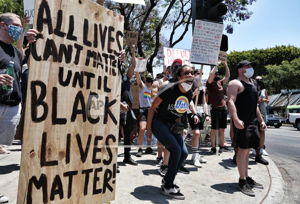 Richard Vogel LGBTQ community members join Black Lives Matter protesters as they hold signs and chant at passing cars in an intersection in West Hollywood, Calif. on Wednesday, June 3, 2020, over the death of George Floyd, a black man who was in police custody in Minneapolis. Floyd died after being restrained by Minneapolis police officers on Memorial Day. (AP Photo/Richard Vogel)