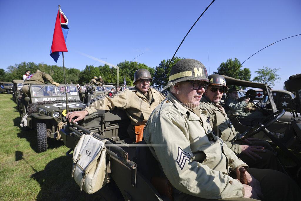 David Vincent World War II history enthusiasts parade in WWII vehicles in Colleville-Montgomery,, Normandy, Saturday June, 5 2021 on the eve of 77th anniversary of the assault that helped bring an end to World War II. While France is planning to open up to vaccinated visitors starting next week, that comes too late for the D-Day anniversary. So for the second year in a row, most public commemoration events have been cancelled. A few solemn ceremonies have been maintained, in the presence of dignitaries and a few guests only. (AP Photo/David Vincent)