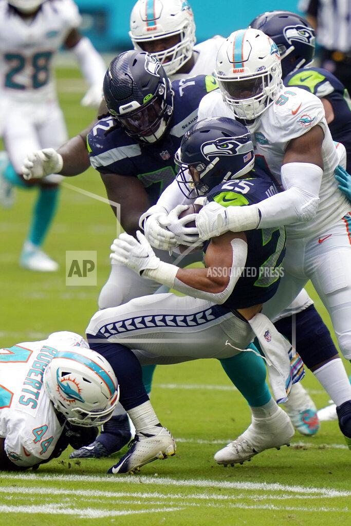Lynne Sladky FILE - In this Oct. 4, 2020, file photo, Miami Dolphins defensive end Emmanuel Ogbah and outside linebacker Elandon Roberts (44) tackle Seattle Seahawks running back Travis Homer (25) during the first half of an NFL football game in Miami Gardens, Fla. The Dolphins' run defense makes even Sunday's matchup against the New York Jets potentially problematic. The Jets are 0-10 and lost 24-0 at Miami in Week 6, but they’re averaging a respectable 4.2 yards per carry and are sure to test the Dolphins' weakness. (AP Photo/Lynne Sladky, File)