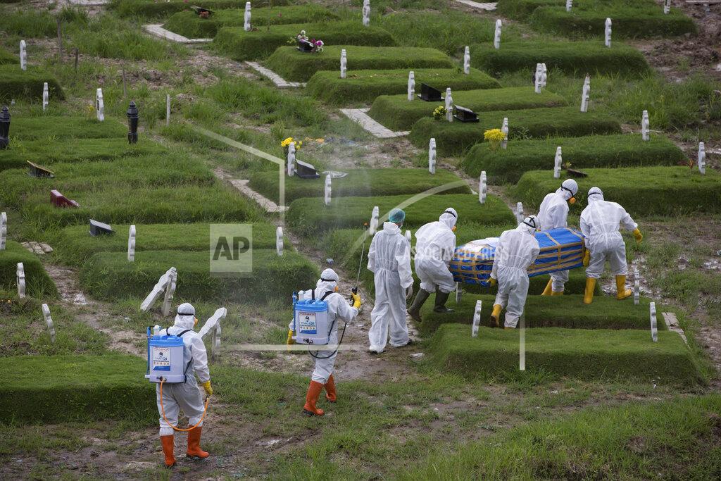 Binsar Bakkara Workers in protective suits carry a coffin containing the body of someone who presumably died of the coronavirus for burial in Medan, North Sumatra, Indonesia, Tuesday, Nov. 24, 2020.(AP Photo/Binsar Bakkara)