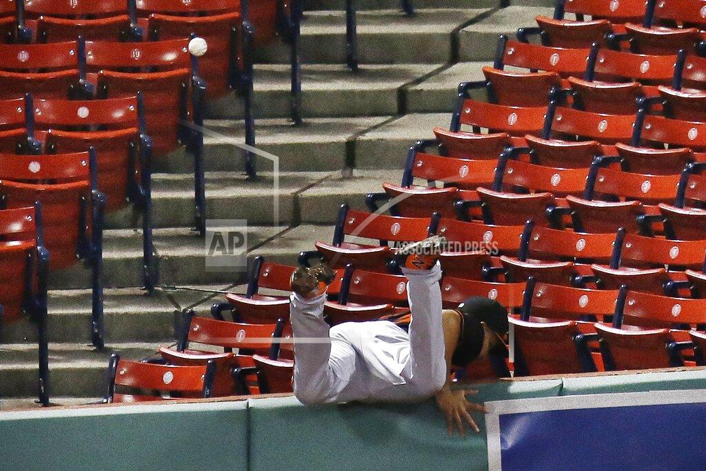 Michael Dwyer Baltimore Orioles' Anthony Santander goes over the wall trying to field the ground-rule double by J.D. Martinezduring the fourth inning of an opening day baseball game at Fenway Park, Friday, July 24, 2020, in Boston. (AP Photo/Michael Dwyer)