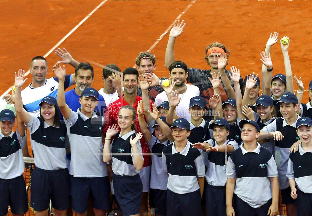Darko Vojinovic In this photo taken on Friday, June 12, 2020, Serbia's Novak Djokovic, centre, poses with volunteers and players during the Adria Tour charity tournament, in Belgrade Serbia. Novak Djokovic’s parents have defended their son and blamed another tennis player for spreading the coronavirus at a series of exhibition matches hosted by the top-ranked player. Djokovic and his wife tested positive for the virus on Tuesday, June 23, 2020. Djokovic’s outspoken father blamed the cancellation of the Adria Tour on Grigor Dimitrov. (AP Photo/Darko Vojinovic)