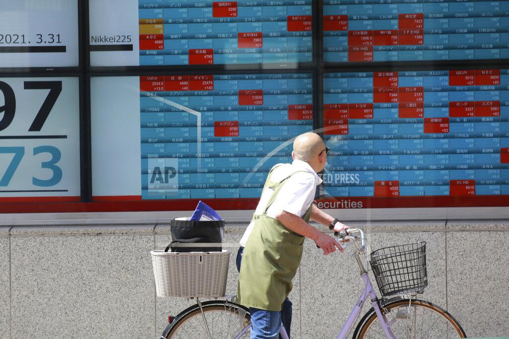 Koji Sasahara A man looks at an electronic stock board of a securities firm in Tokyo, Wednesday, March 31, 2021. Asian shares were mixed Wednesday as data showed a strong economic recovery in China but worries lingered about the coronavirus pandemic. (AP Photo/Koji Sasahara)
