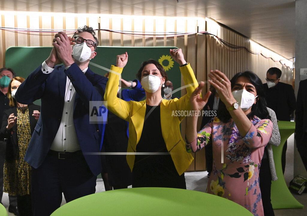 Marijan Murat Andreas Schwarz, parliamentary party leader of the Greens in Baden-Wuerttemberg, Sandra Detzer, state leader of the Greens and Muhterem Aras, president of the state parliament react after the announcement of the first forecast of the results of the state elections in Baden-Wuerttemberg. Elections in two German states on Sunday pose a difficult test for Chancellor Angela Merkel's party, six months before a national vote that will determine who succeeds the country's longtime leader. (Marijan Murat/dpa via AP)