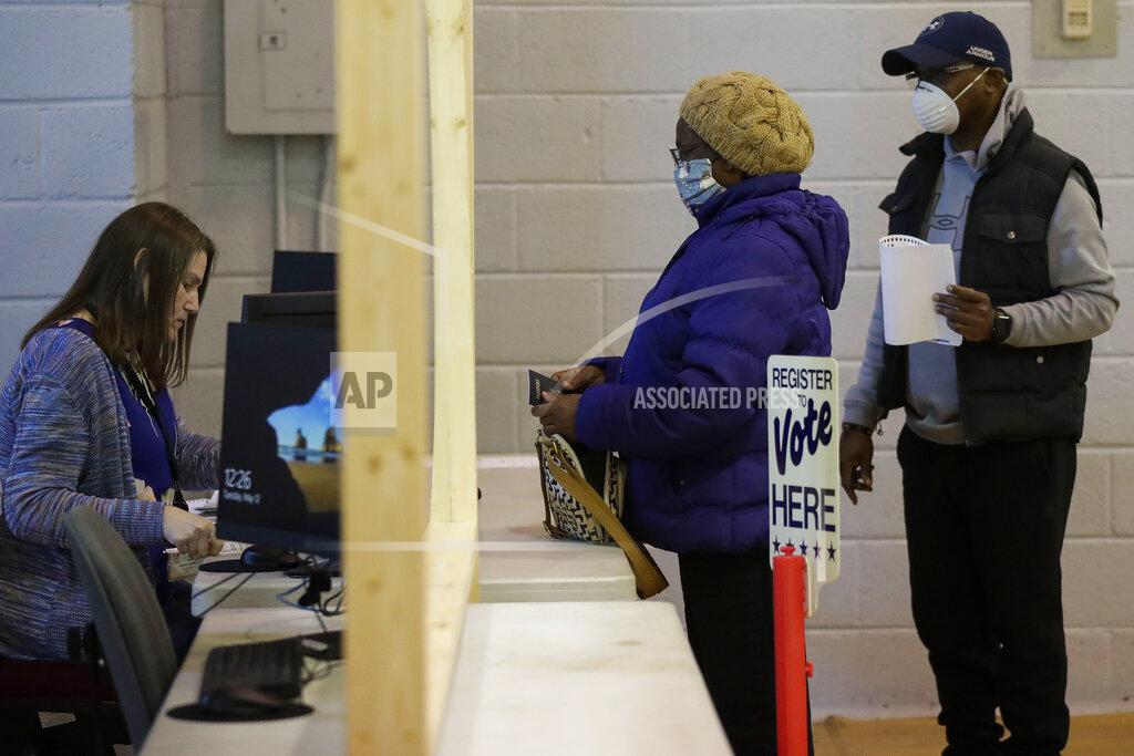 Tork Mason Marjorie Myers, center, registers to vote with her son-in-law, Carl Gayle, in the Wisconsin 7th District special election on Tuesday, May 12, 2020, at the Oak Avenue Community Center in Marshfield, Wis. Republican Tom Tiffany and Democrat Tricia Zunker are vying to fill the vacancy left by Republican Sean Duffy, who resigned from the seat in September. (Tork Mason/The Post-Crescent via AP)