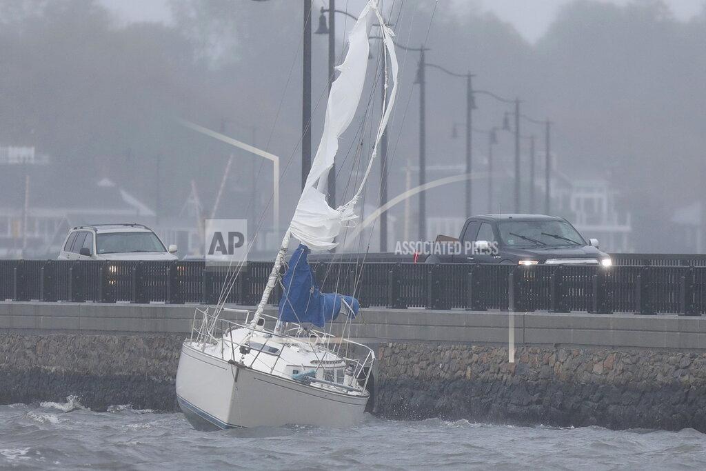 Peter Pereira A sail boat runs aground into the Bridge Street causeway in Dartmouth, Mass. on Wednesday, Oct. 27, 2021 as nor'easter storm slams into the region. (Peter Pereira/The Standard-Times via AP)