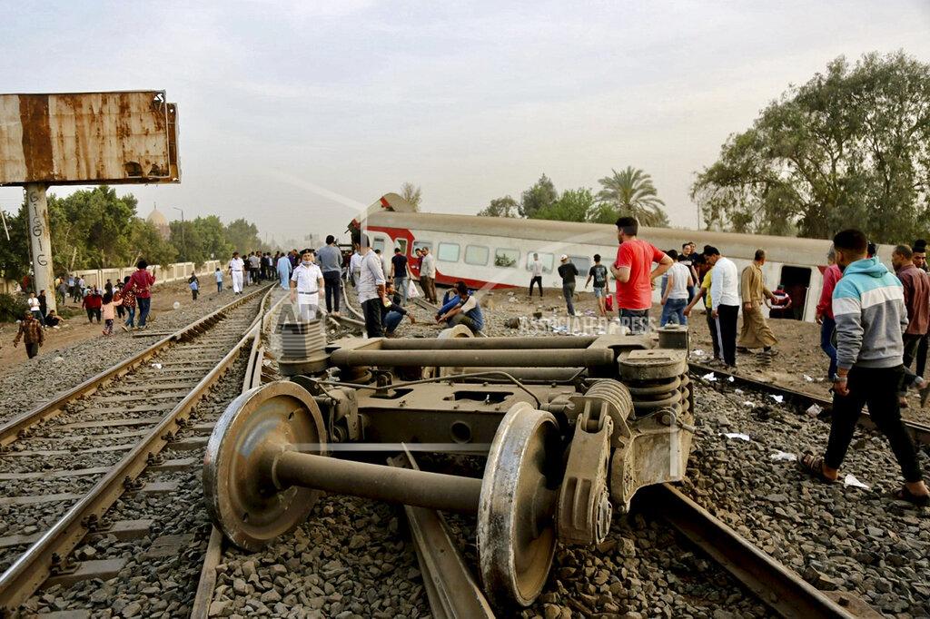Fadel Dawood People gather at the site where a passenger train derailed injuring at least 100 people, near Banha, Qalyubia province, Egypt, Sunday, April 18, 2021. At least eight train wagons ran off the railway, the provincial governor's office said in a statement. (AP Photo/Fadel Dawood)