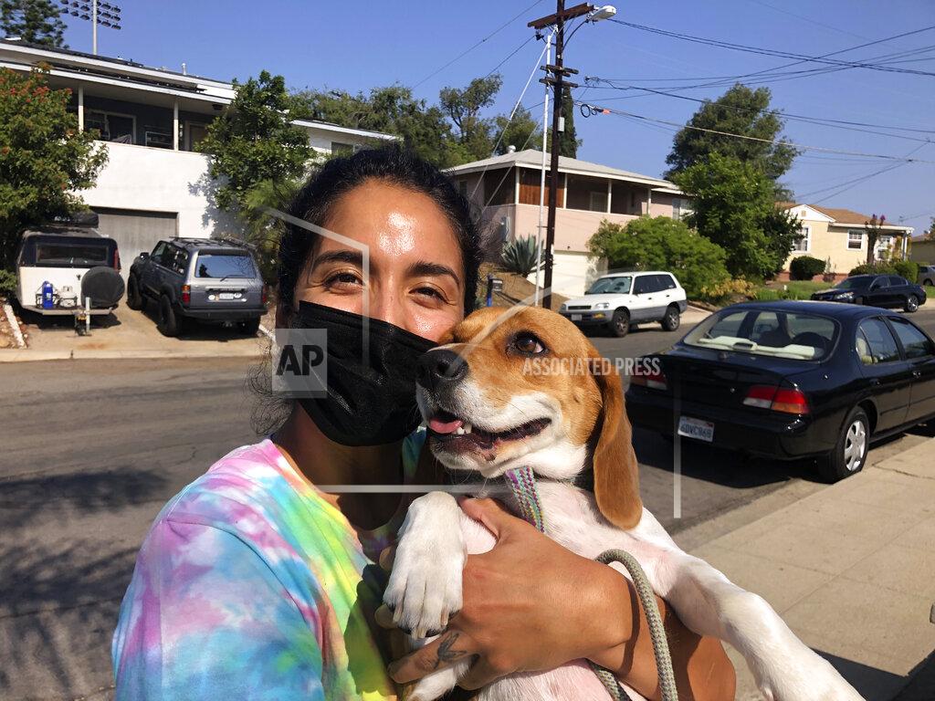 Julie Watson Briana Mendoza, 30, on Tuesday, Sept. 14, 2021, poses with her dog outside a polling site at a San Diego high school. Mendoza said she voted against recalling California Gov. Gavin Newsom. She said the state does not need to replace a governor who has been working to curb the spread of the coronavirus. (AP Photo by Julie Watson)