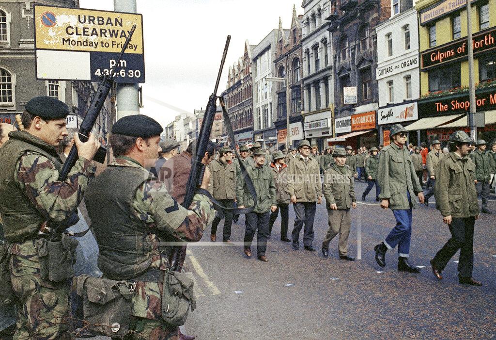 Uncredited FILE - In this Aug. 1972 file photo British troops watch as members of the Ulster Defence Association parade through Belfast, Northern Ireland. The chaotic scenes during a week of violence on the streets of Northern Ireland have stirred memories of decades of Catholic-Protestant conflict, known as "The Troubles." A 1998 peace deal ended large-scale violence but did not resolve Northern Ireland's deep-rooted tensions. (AP Photo, File)
