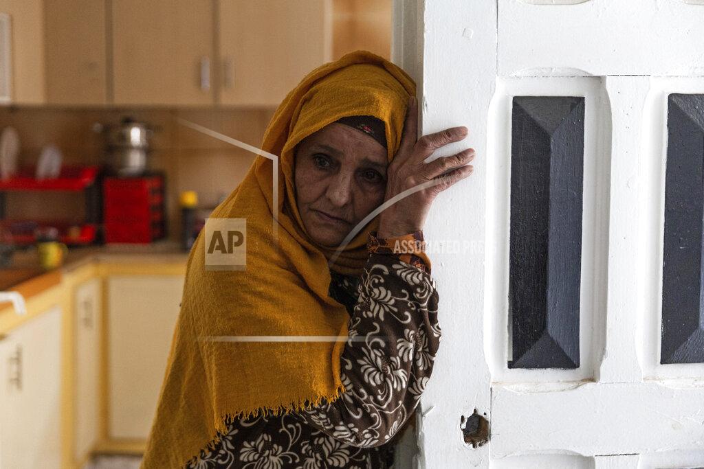 Riadh Dridi Zina Sehi looks at her son, Hosni Kalaia, in Kasserine, Tunisia, on Friday, Dec. 11, 2020. Hundreds of desperate Tunisians have set themselves on fire over the past 10 years in an act of protest. In 2014, Sehi, now 68, tried to burn herself to death in front of the presidential palace in Tunis, protesting the government failure to support the family financially. (AP Photo/Riadh Dridi)