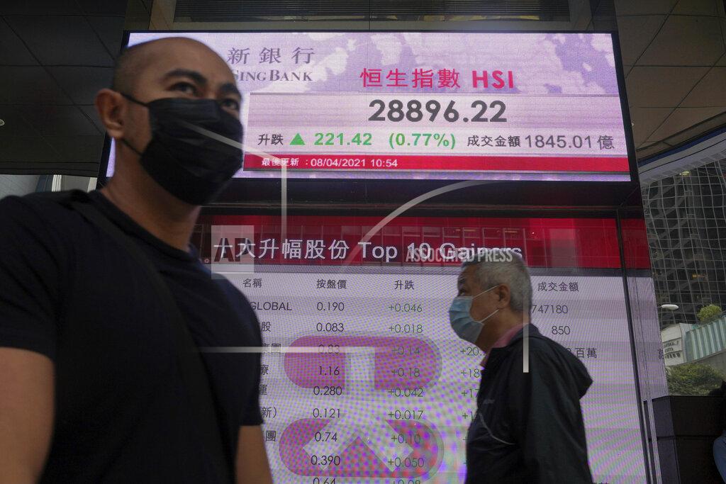 Vincent Yu People walk past a bank's electronic board showing the Hong Kong share index in Hong Kong Thursday, April 8, 2021. Shares were mostly higher in Asia on Thursday after a mixed close on Wall Street, where gains for several Big Tech stocks nudged the S&P 500 to a second record high in three days.(AP Photo/Vincent Yu)
