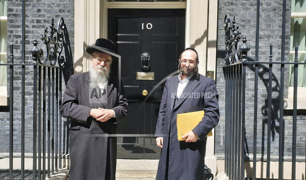 Chaya Spitz In this photo provided by Chaya Spitz, Rabbi Avrohom Pinter, left, stands beside Joel Friedman, right, the director of Public Affairs for the Interlink Foundation, an umbrella organization for Orthodox Jewish charities on July 4, 2019 in Downing Street, London. Pinter gave his life to save his neighbors. When the British government ordered a lockdown to slow the spread of coronavirus, Pinter went door-to-door to deliver the public health warning to the ultra-Orthodox Jews in northeast London. Within days, the 71-year-old rabbi had caught the disease and died. (Chaya Spitz via AP)