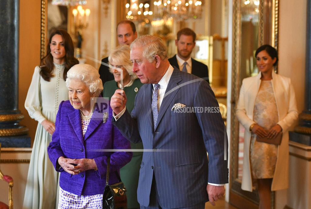 Dominic Lipinski FILE - In this Tuesday, March 5, 2019 file photo, Britain's Queen Elizabeth II is joined by Prince Charles, the Prince of Wales, and at rear, from left, Kate, Duchess of Cambridge, Camilla, Duchess of Cornwall, Prince William, Prince Harry and Meghan, Duchess of Sussex during a reception at Buckingham Palace, London, to mark the fiftieth anniversary of the investiture of the Prince of Wales. Britain and its royal family are absorbing the tremors from a sensational television interview with Prince Harry and Meghan. The couple said they encountered racist attitudes and a lack of support that drove Meghan to thoughts of suicide. The couple gave a deeply unflattering depiction of life inside the royal household, depicting a cold, uncaring institution that they had to flee to save their lives. Meghan told Oprah Winfrey that at one point “I just didn’t want to be alive anymore.” Meghan, who is biracial, said that when she was pregnant with son Archie, there were “concerns and conversations about how dark his skin might be when he’s born.” (Dominic Lipinski/Pool via AP, File)