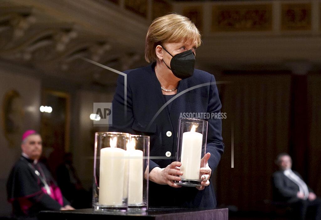 Michael Sohn German Chancellor Angela Merkel holds a candle during a memorial service in Berlin, Germany, Sunday, April 18, 2021 in remembrance of Germany's corona dead. (AP Photo/Michael Sohn, pool)