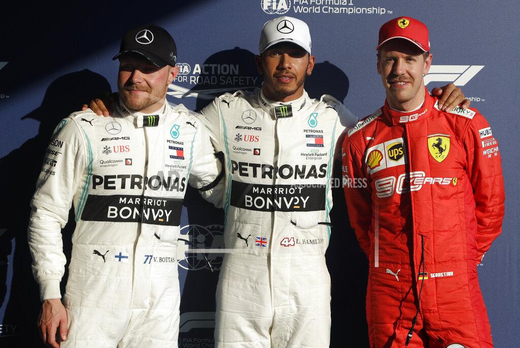 Mercedes drivers Lewis Hamilton of Britain, center, and Valtteri Bottas of Finland, left, pose with Ferrari driver Sebastian Vettel of Germany after qualifying for the Australian Grand Prix in Melbourne, Australia, Saturday, March 16, 2019. Hamilton qualified first, Bottas second and Vettel in third place on the grid for the first race of the year, Sunday. (AP Photo/Rick Rycroft)