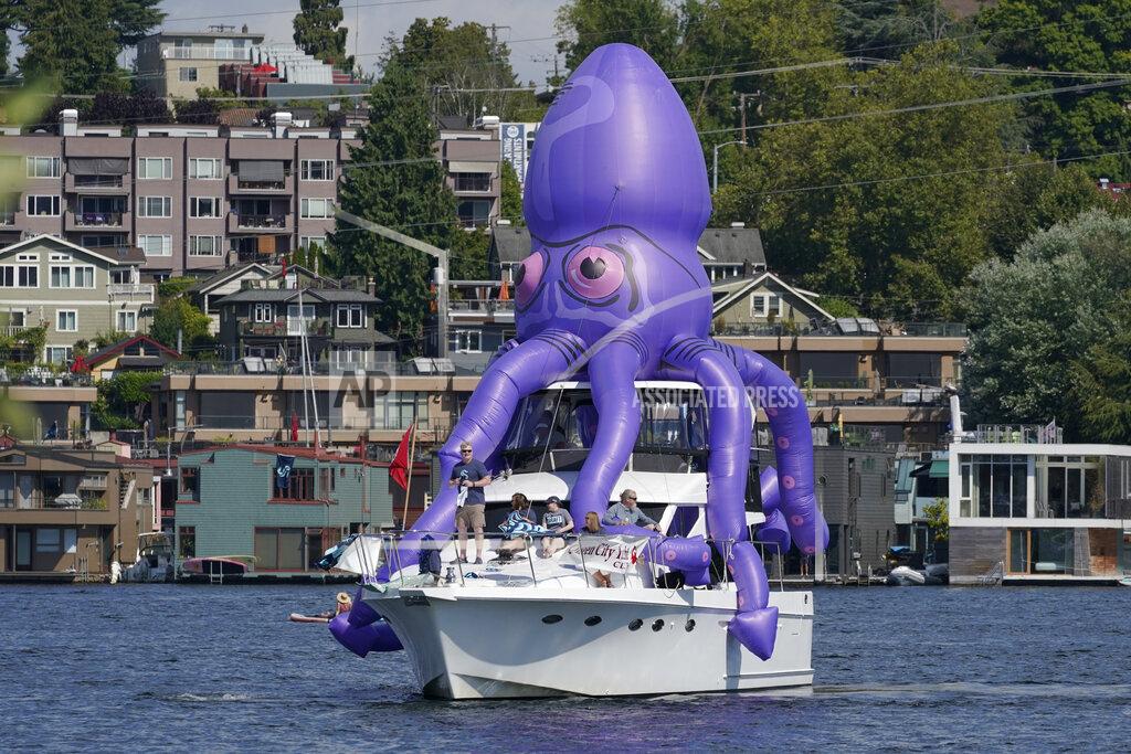 Ted S. Warren A boat with an inflatable octopus sails on Lake Union, Wednesday, July 21, 2021, in Seattle near the park where the Seattle Kraken NHL hockey team was holding its expansion draft event. (AP Photo/Ted S. Warren)