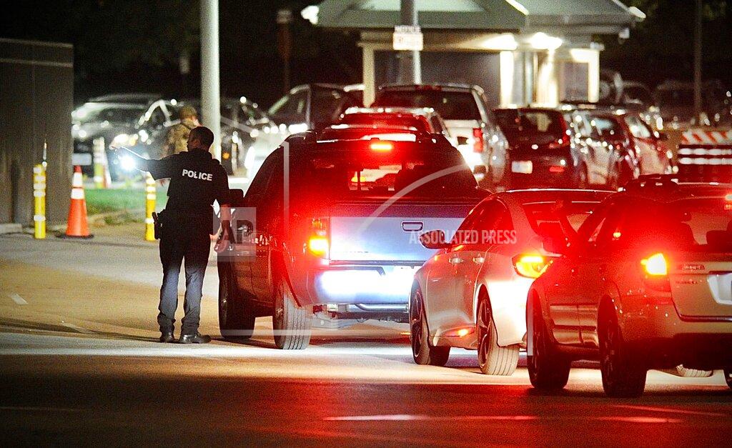 Marshall Gorby A police officer talks to a driver at a gate at Wright-Patterson Air Force Base, Ohio, near Dayton, Thursday, Sept. 9, 2021, The base was put on lockdown to investigate reports of a shooter on the campus, according to the airbase. (Marshall Gorby/Dayton Daily News via AP)