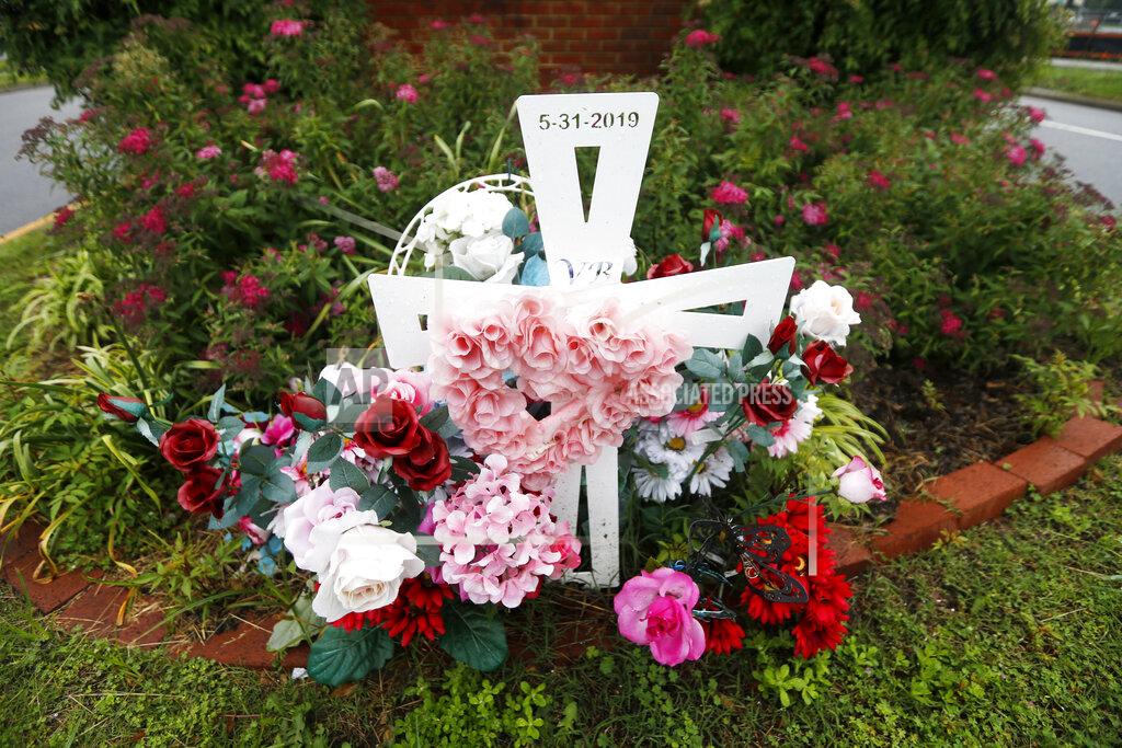 Steve Helber In this May 22, 2020, photo, a group of flowers and a cross mark the entrance to Jason Nixon's neighborhood in Virginia Beach, Va. The flowers are a memorial to Kate Nixon who was killed in last year's shootings at a Virginia Beach municipal building. (AP Photo/Steve Helber)