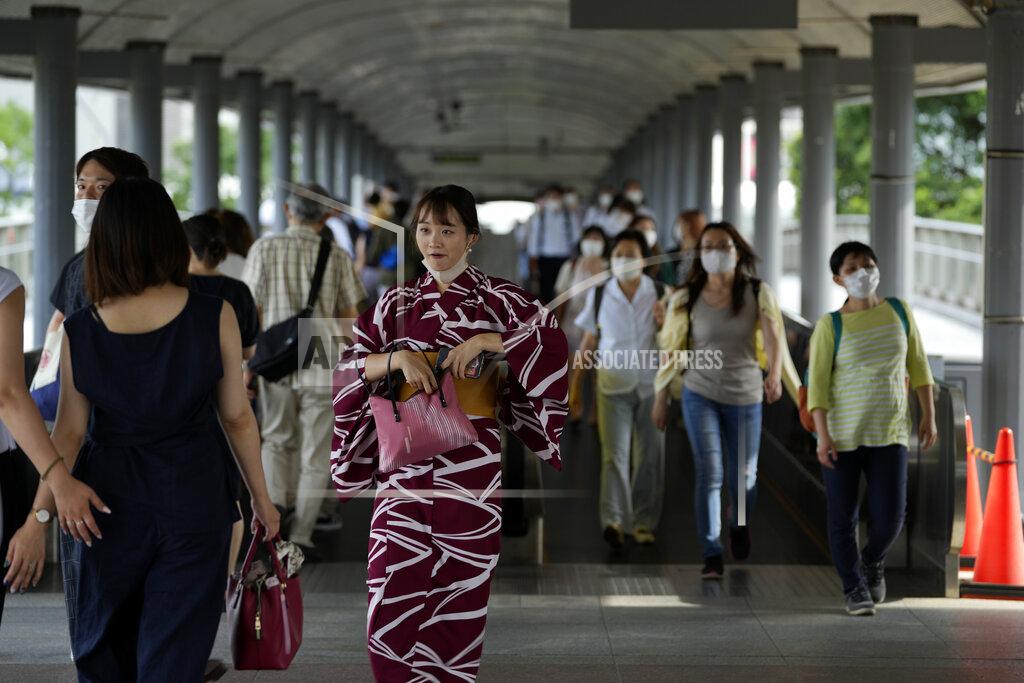 Kiichiro Sato People wearing protective masks pass through a pedestrian bridge Friday, July 30, 2021, in Yokohama, south of Tokyo. Japan is set to expand the coronavirus state of emergency in Tokyo to neighboring prefectures including Saitama, Chiba and Kanagawa, where Yokohama is located, and the western city of Osaka as infections surge to new highs while the capital hosts the Olympics. (AP Photo/Kiichiro Sato)