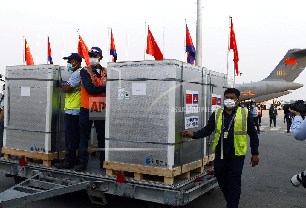 Heng Sinith Workers pull boxes loaded with COVID-19 vaccines before a handing over ceremony at Phnom Penh International Airport, in Phnom Penh, Cambodia, Sunday, Feb. 7, 2021. Cambodia on Sunday received its first shipment of COVID-19 vaccine, a donation of 600,000 doses from China, the country's biggest ally. Beijing has been making such donations to several Southeast Asian and African nations in what has been dubbed "vaccine diplomacy," aimed especially at poorer countries like Cambodia. (AP Photo/Heng Sinith)