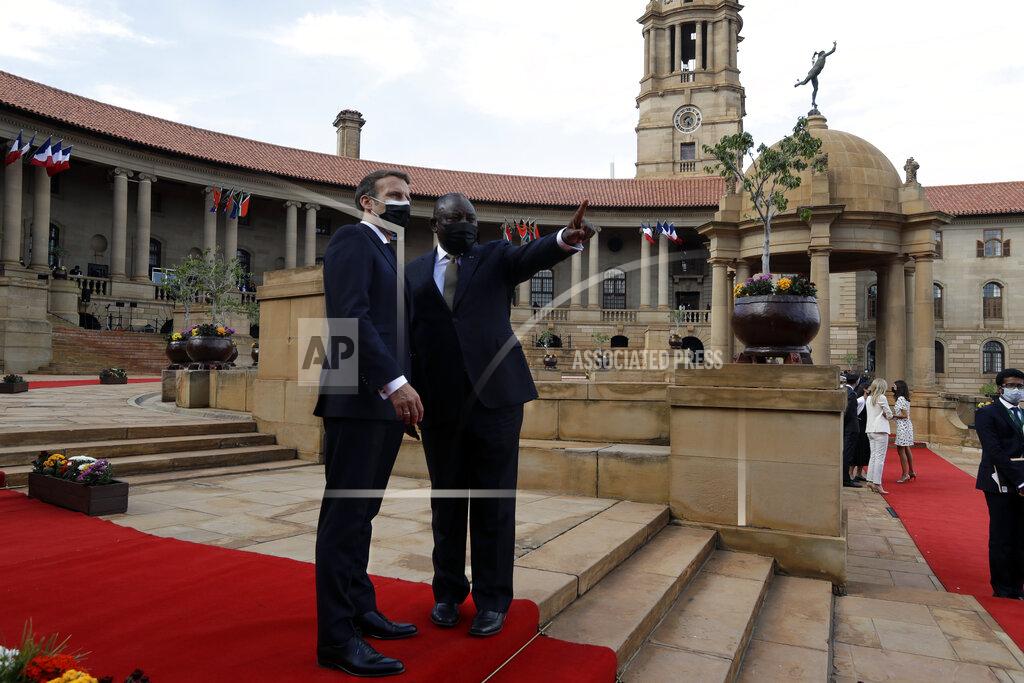 Themba Hadebe South African President Cyril Ramaphosa, center right, and his French counterpart Emmanuel Macron talk during a welcoming ceremony at the government's Union Buildings, in Pretoria, South Africa, Friday, May 28, 2021. Macron is on a two-day official visit to the country. (AP Photo/Themba Hadebe, Pool)