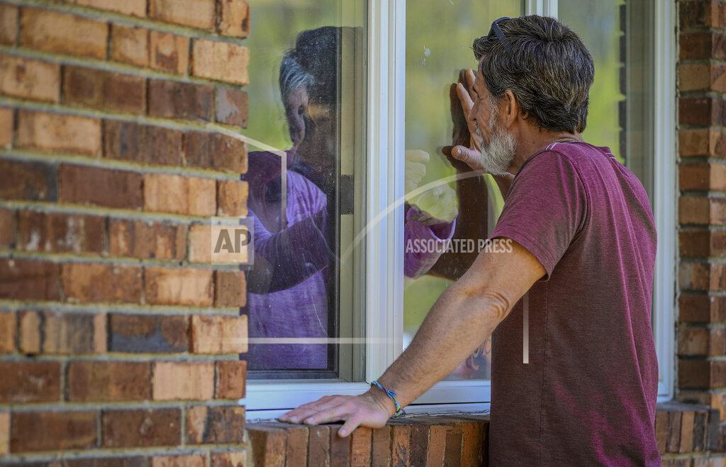Chris Ehrmann FILE - Jack Campise talks with his mother, Beverly Kearns, through her apartment window at the Kimberly Hall North nursing home, Thursday, May 14, 2020 in Windsor, Conn. Connecticut essential state employees, such as nurses, long-term care workers, prison staff and first responders who worked long hours during the COVID-19 pandemic, are still waiting for "hero pay" from $22.5 million in federal pandemic funds set aside in the state budget. (AP Photo/Chris Ehrmann, File)
