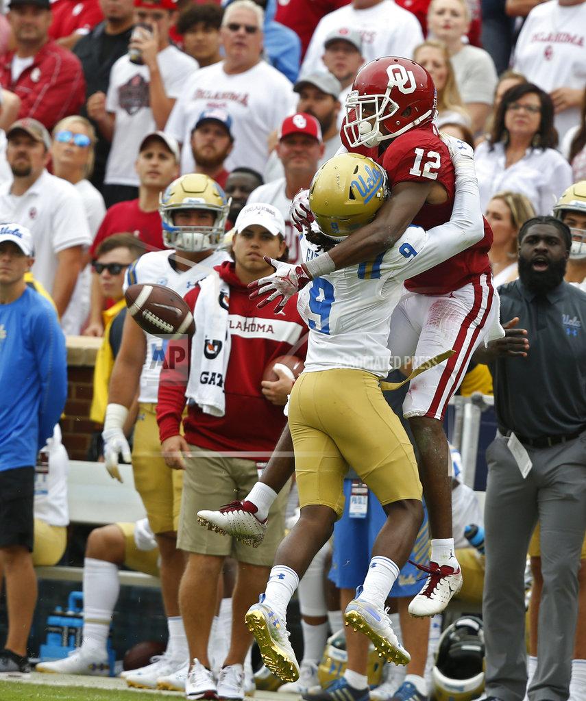 Sue Ogrocki UCLA defensive back Elijah Gates (9) interferes with Oklahoma wide receiver A.D. Miller (12) as Miller attempts to catch a pass in the second half of an NCAA college football game in Norman, Okla., Saturday, Sept. 8, 2018. Oklahoma won 49-21. (AP Photo/Sue Ogrocki)