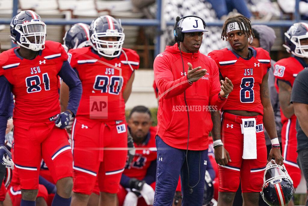 Rogelio V. Solis Jackson State football coach Deion Sanders, second from right, confers with quarterback Quincy Casey (8) as tight end Robert Washington Jr. (81) and defensive lineman Brian Mitchell (90) listen in during the second half of an NCAA college football game against Edward Waters in Jackson, Miss., Sunday, Feb. 21, 2021. (AP Photo/Rogelio V. Solis)