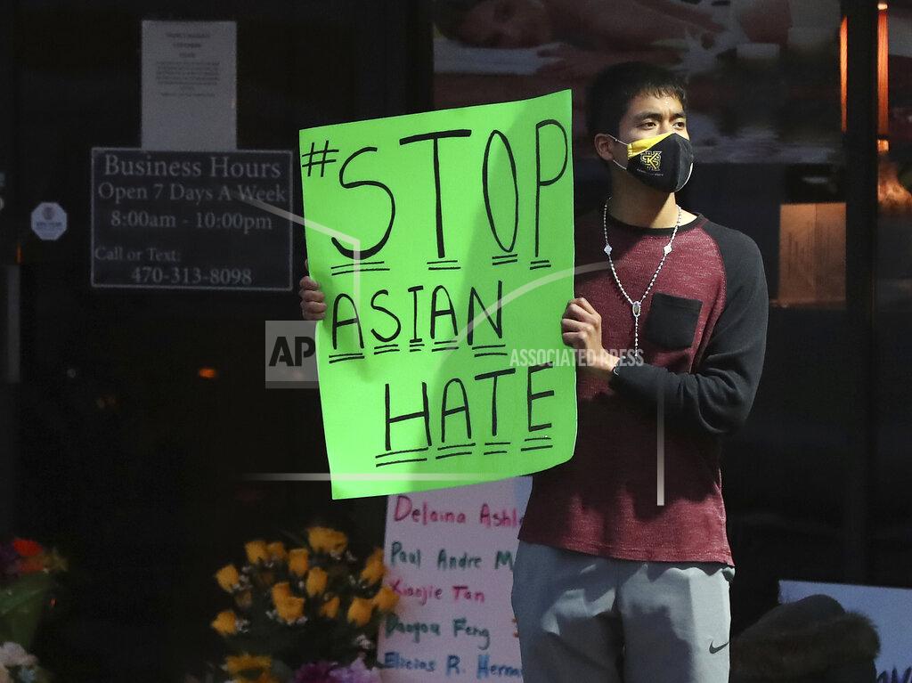 Curtis Compton Jesus Estrella, of Kennesaw, Ga., stands outside Youngs Asian Massage on Wednesday, March 17, 2021, in Acworth, Ga., where four people were fatally shot Tuesday. A white gunman was charged Wednesday with killing eight people at three Atlanta-area massage parlors in an attack that sent terror through the Asian American community, which has increasingly been targeted during the coronavirus pandemic. Estrella, who is of Asian and Hispanic descent, said, "I felt I had to come and support the community." (Curtis Compton/Atlanta Journal-Constitution via AP)