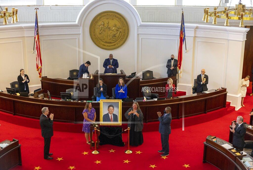 Robert Willett Caroline Basnight, left, and sister Vicki Basnight, unveil a portrait of their father, former Senate President Pro Tempore Marc Basnight during a ceremony on Tuesday, Sept. 21, 2021 at the General Assembly in Raleigh, N.C. Basnight died in December 2020 and served 13 terms in the North Carolina Senate. (Robert Willett/The News & Observer via AP)