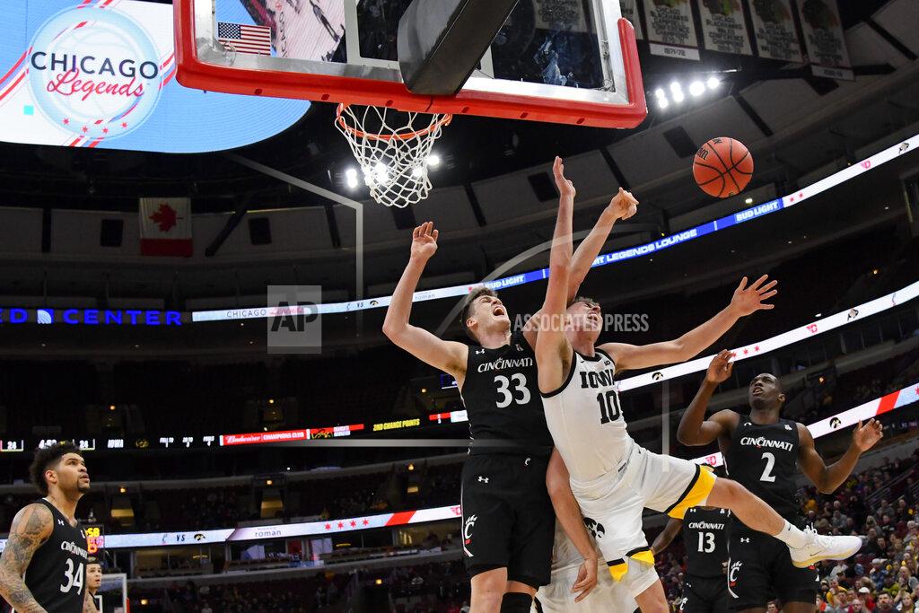 Matt Marton Iowa guard Joe Wieskamp (10) and Cincinnati center Chris Vogt (33) and guard Keith Williams (2) look for a rebound during the first half of an NCAA college basketball game Saturday, Dec. 21, 2019, in Chicago. (AP Photo/Matt Marton)