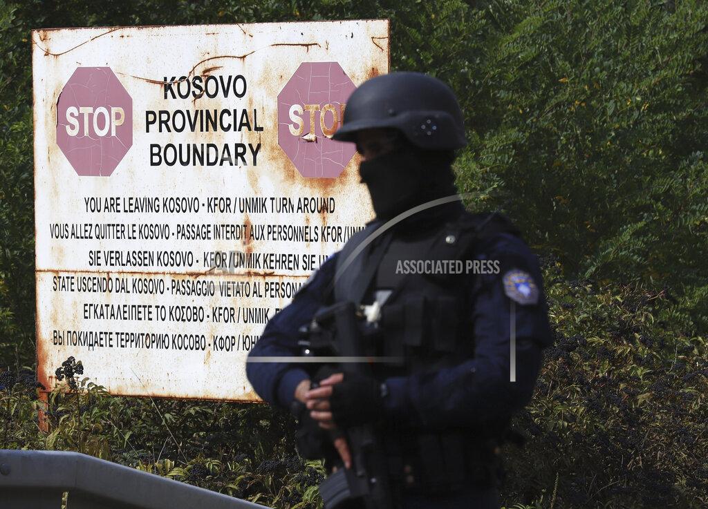 Bojan Slavkovic A Kosovo special police officer stands on the road near the northern Kosovo border crossing of Jarinje, Monday, Sept. 20, 2021. Tensions have soared on the border between Kosovo and Serbia as Pristina authorities started implementing a rule to remove Serbian license plates from cars entering Kosovo. Kosovo special police with armored vehicles were deployed Monday on the tense border as hundreds of Kosovo Serbs reportedly drove there in their cars to protest the move. (AP Photo/Bojan Slavkovic)