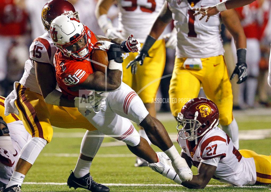 Rick Bowmer Utah running back Zack Moss (2) carries the ball as Southern California's Talanoa Hufanga (15) and Ajene Harris (27) make the tackle in the second half during an NCAA college football game Saturday, Oct. 20, 2018, in Salt Lake City. (AP Photo/Rick Bowmer)