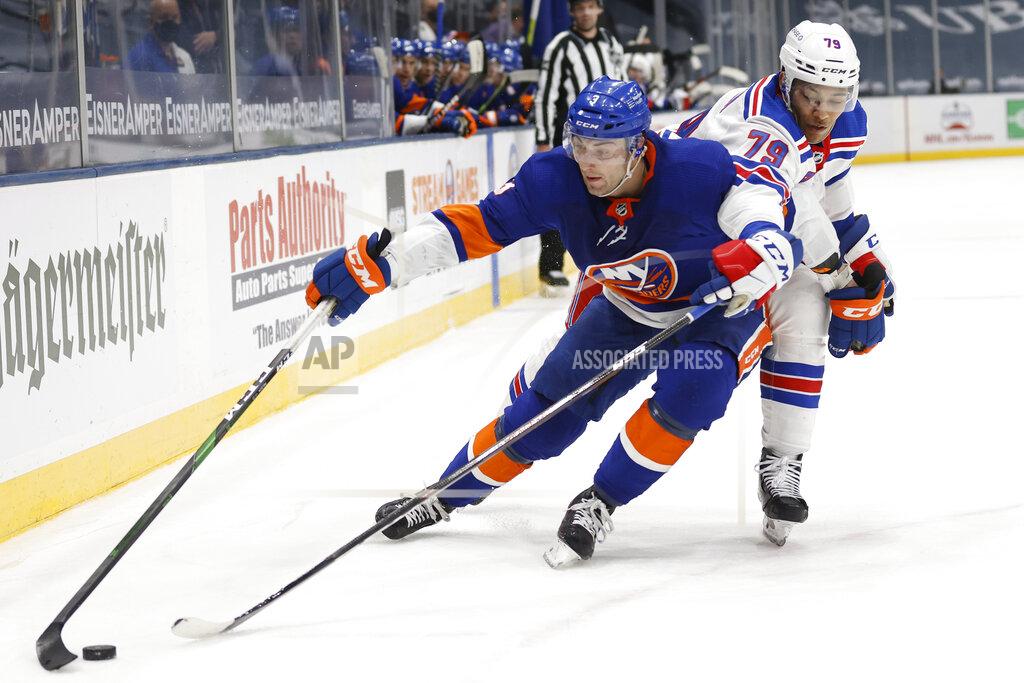 Jason Decrow New York Islanders' Adam Pelech (3) fights for possession against New York Rangers' K'Andre Miller (79) during the second period of an NHL hockey game Friday, April 9, 2021, in Uniondale, N.Y. (AP Photo/Jason DeCrow)