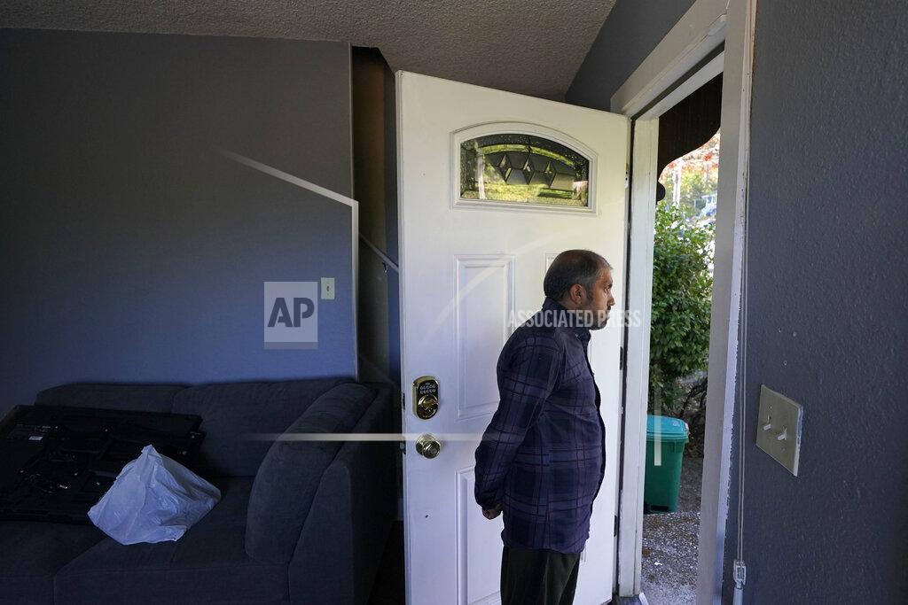 Ted S. Warren Abdul, who worked as a mechanic before he left Kabul, Afghanistan with his family about a month ago, looks out the doorway of a rental house, Thursday, Sept. 16, 2021, where his family have been provided a place to stay in Seattle. The home is owned by Thuy Do, who was nine years old when her family arrived in the United States from Vietnam in the 1980s. Now Do and her husband have offered their vacant rental home to refugee resettlement groups to house newly arriving Afghans in need of a place to stay. (AP Photo/Ted S. Warren)