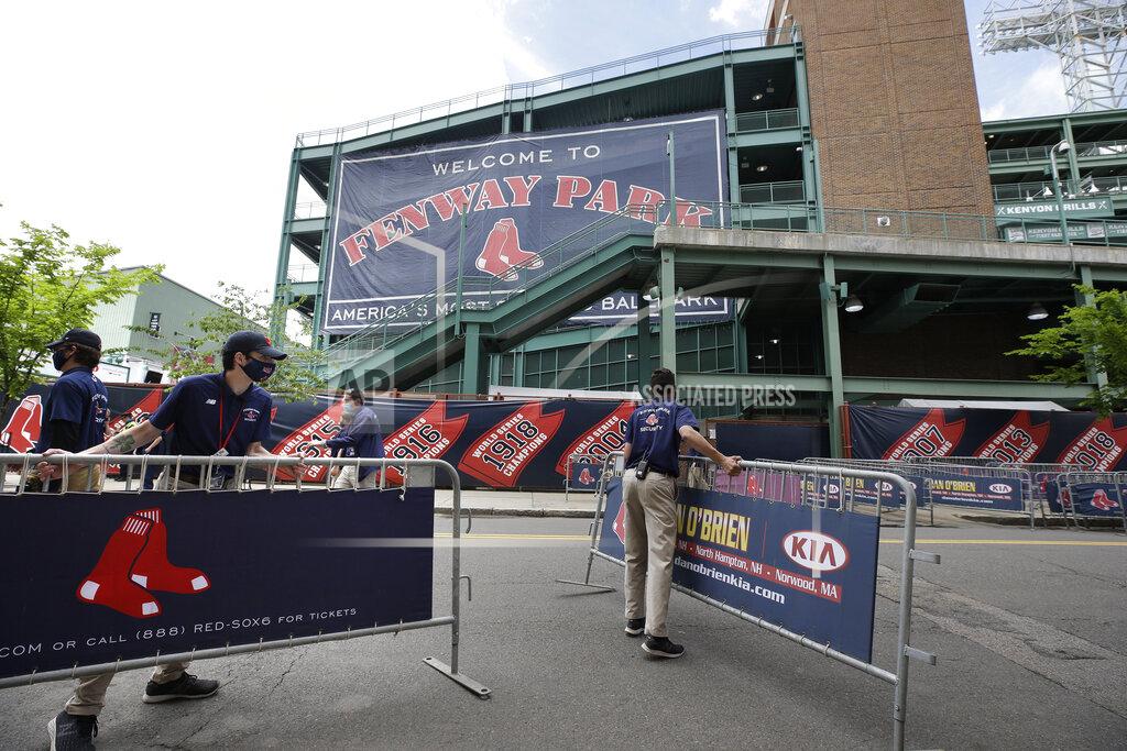 Steven Senne Boston Red Sox personnel move barriers Wednesday, July 1, 2020, near an entrance to Fenway Park baseball stadium, in Boston. The Red Sox are to start workouts at the ballpark, Friday, July 3, with a goal of playing 60 games for the 2020 season, due to the coronavirus pandemic. (AP Photo/Steven Senne)