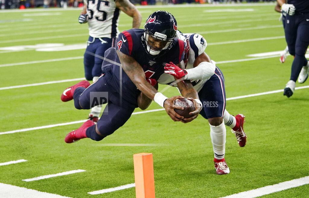 David J. Phillip FILE - In this Dec. 1, 2019, file photo, Houston Texans quarterback Deshaun Watson (4) dives past New England Patriots outside linebacker Elandon Roberts (52) to score a touchdown during the second half of an NFL football game in Houston. The photo was part of a series of images by photographer David J. Phillip which won the Thomas V. diLustro best portfolio award for 2019 given out by the Associated Press Sports Editors during their annual winter meeting in St. Petersburg, Fla. (AP Photo/David J. Phillip, File)