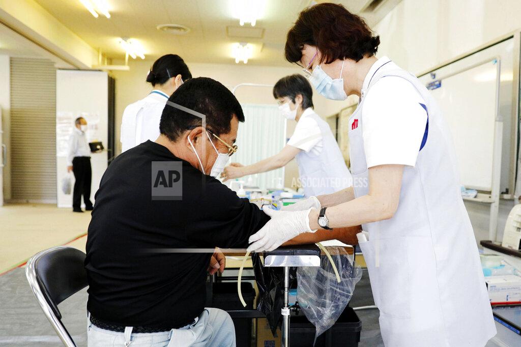 Uncredited A nurse takes a blood sample from a resident in Natori, Miyagi prefecture, northern Japan, Monday, June 1, 2020. The Japanese Health Ministry began testing around 10,000 people for coronavirus antibodies on Monday to better understand its spread. (Kyodo News via AP)