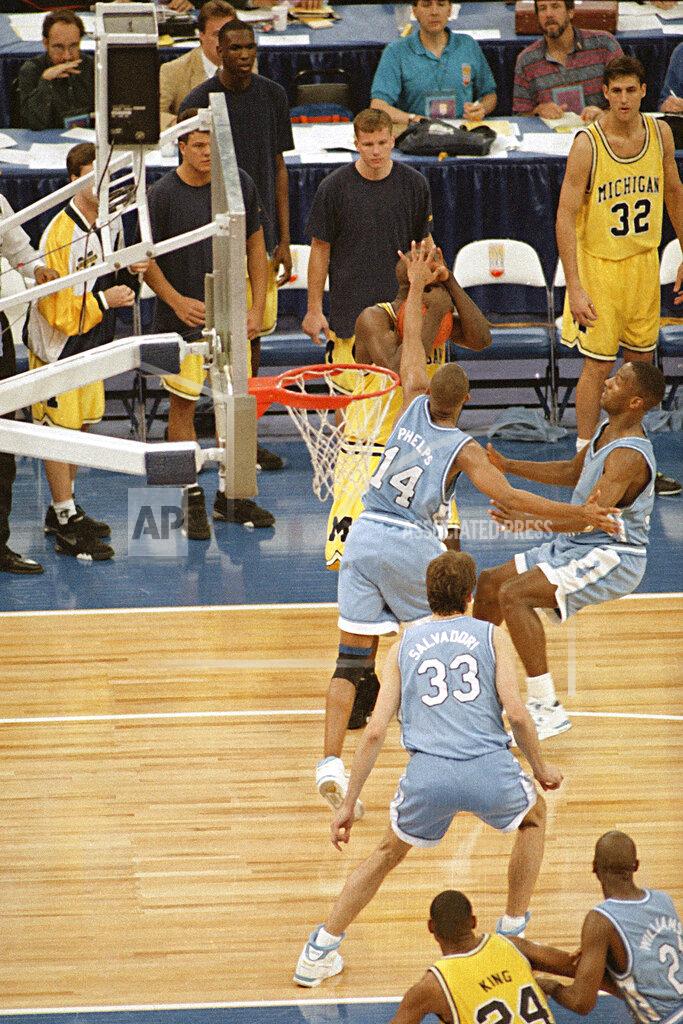 Bill Haber FILE - In this April 5, 1993 file photo, Michigan's Chris Webber, guarded by North Carolina's Derrick Phelps (14), calls a timeout in the closing moments of the NCAA Final Four championship game at the Superdome in New Orleans. Webber was called for a technical foul because they had no time outs left and North Carolina went on to win, 77-71. (AP Photo/Bill Haber, File)