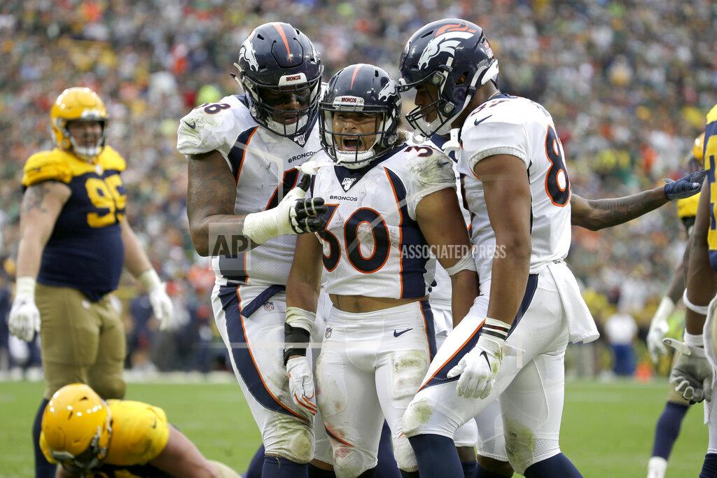 Mike Roemer Denver Broncos running back Phillip Lindsay (30) is congratulated by teammates Elijah Wilkinson, left, and Noah Fant, right, after scoring during the second half of an NFL football game against the Green Bay Packers Sunday, Sept. 22, 2019, in Green Bay, Wis. (AP Photo/Mike Roemer)