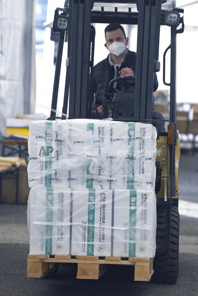 Noemi Bruzak An employee unloads the newly arrived coronavirus vaccines from Chinese pharmaceutical company Sinopharm at the logistics base set up to in the parking lot of the government office in the 13th district of Budapest, Hungary, Monday, March 29, 2021. (Noemi Bruzak/MTI via AP)