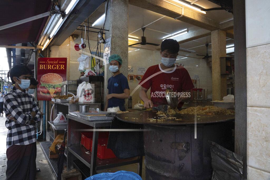 Pyae Sone Win Customers wearing face masks wait for take-away meals ordered at a restaurant in Yangon, Myanmar,Monday, Sept. 21, 2020. Myanmar, faced with a rapidly rising number of coronavirus cases and deaths, has imposed the tightest restrictions so far to fight the spread of the disease in Yangon, the country's biggest city and main transportation hub. (AP Photo/Pyae Sone Win)